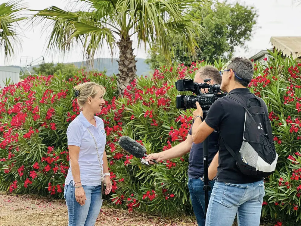 Sabine, figure d'Esterel Caravaning, interviewée par une équipe de télévision au camping