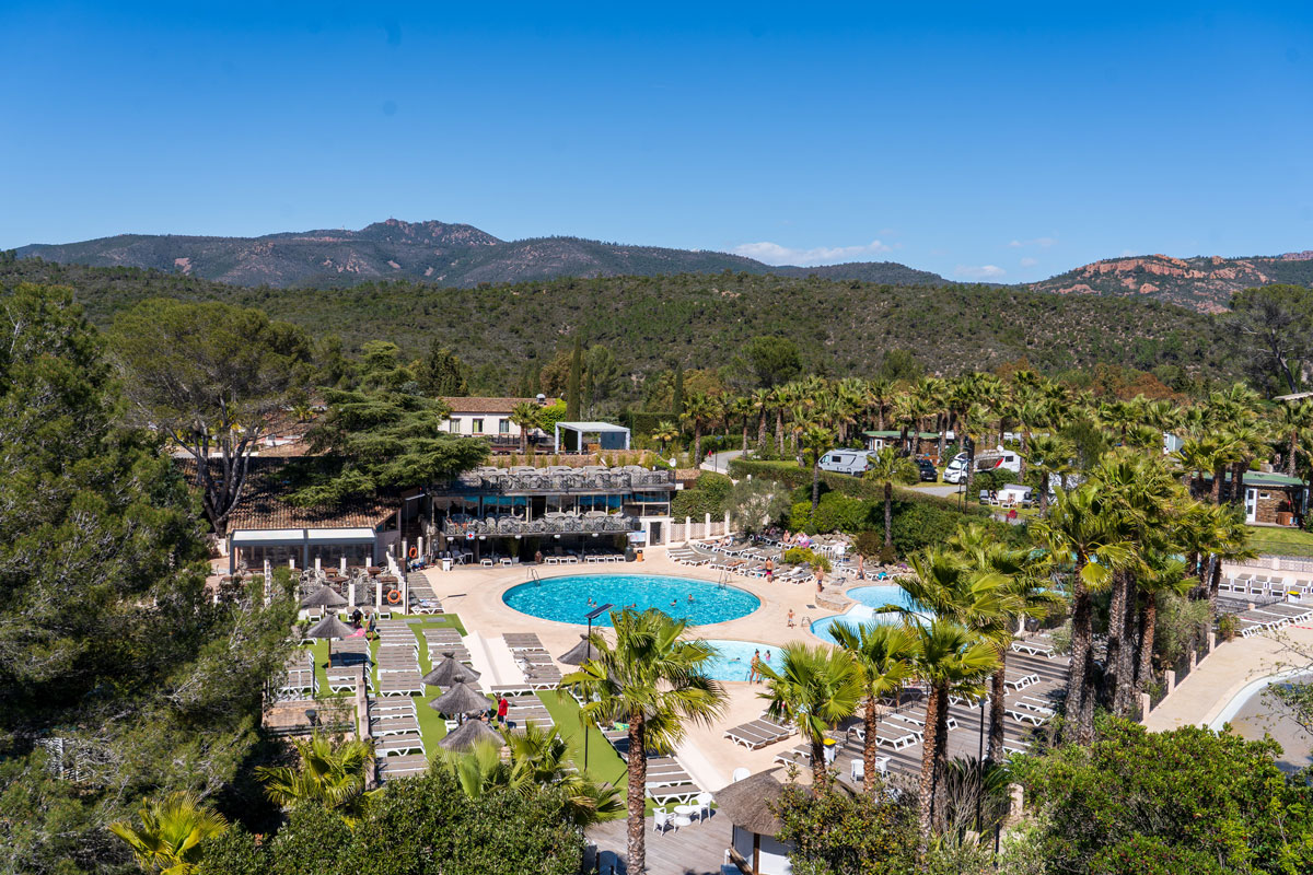 Luftaufnahme des Pools, der Sonnenliegen und des Solariums von Esterel Caravaning mit Blick auf das Esterel-Massiv