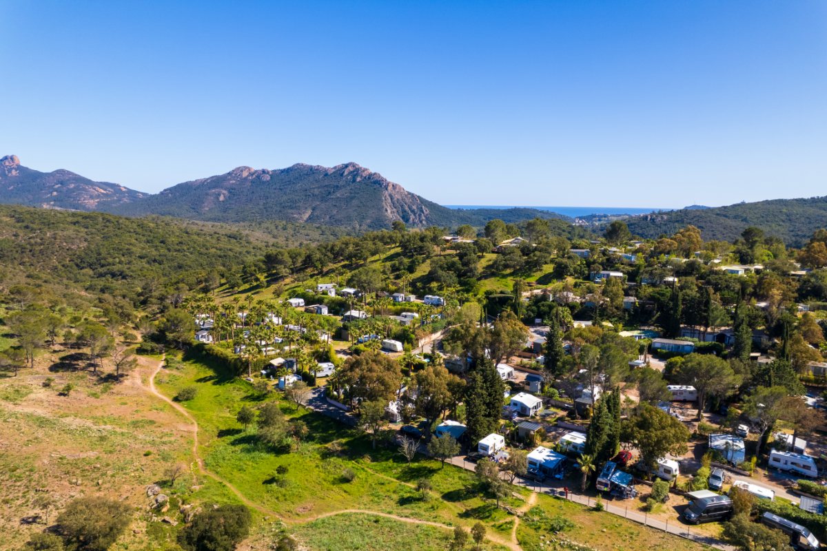Luftaufnahme von Esterel Caravaning in Agay mit Stellplätzen im Grünen und dem Esterel-Massiv im Hintergrund